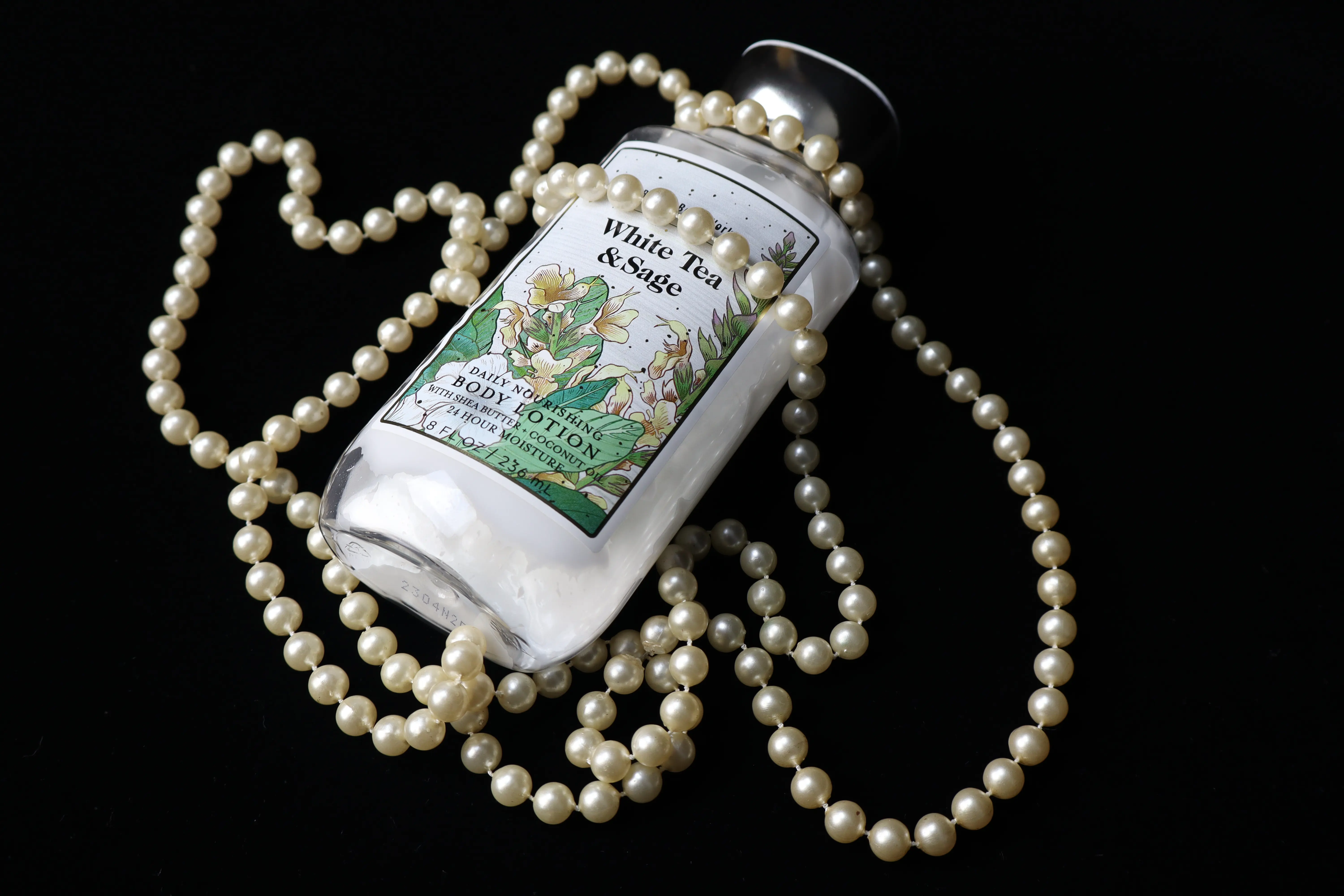 Lotion bottle with beads on top of it